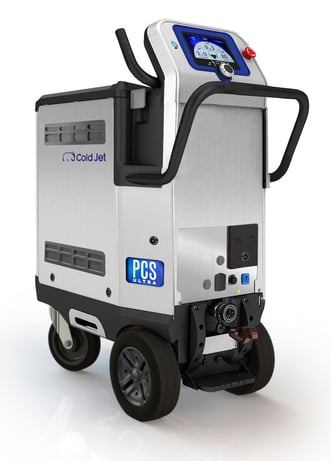 Eine Nahaufnahme des Trockeneisstrahlgeräts Cold Jet Aero2 PCS Ultra. Die Maschine hat ein Gehäuse aus silbernem Metall, schwarze Griffe und Rollen, sowie ein blau beleuchtetes Bedienfeld oben.