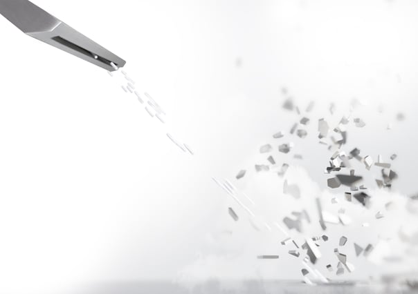 Nahaufnahme einer Trockeneisstrahldüse, die kleine Trockeneispartikel in einem feinen Strahl abgibt. Die Partikel zerplatzen beim Aufprall und erzeugen eine Wolke aus gelöstem Material, symbolisierend die Effektivität des Reinigungsprozesses.